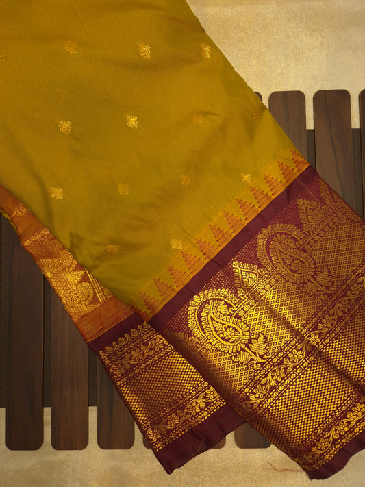 Brass Yellow Gadwal Silk Saree with all-over Golden Buttas and Intricate Design on Wine Colour Border